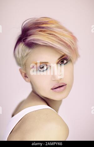 Beautiful blonde hair woman posing in studio. Close up portrait of young attractive model.Smiling lady with stylish short hair Stock Photo