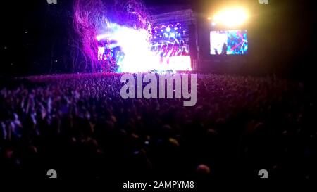 Concert stage with crowd of people standing in front, performance at stadium Stock Photo