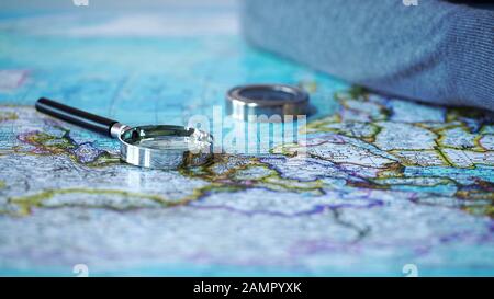Magnifying glass and compass on map, adventure planning, vacation travel Stock Photo