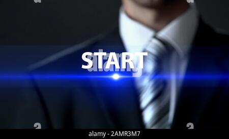 Start, man in official suit standing in front of screen, first steps, beginning Stock Photo