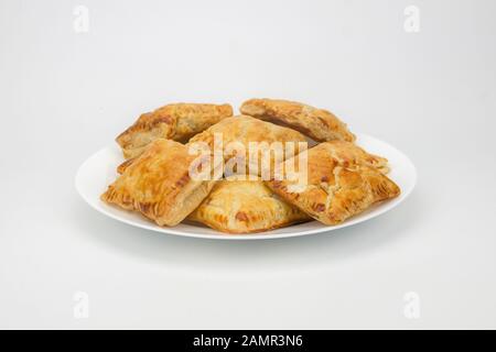 Guava puff pastry on a plate isolated in white background.Groups of puff pastry on a plate on white background. Exquisite sweet stuffed with guava. Stock Photo