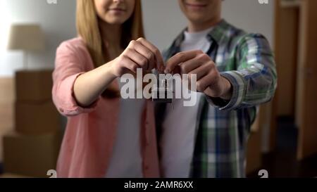 Happy couple showing keys from new apartment, affordable bank lending, mortgage Stock Photo