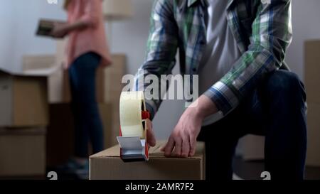 Young couple packing their things in boxes, moving from dormitory to own house Stock Photo
