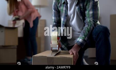 Young family packing their things in boxes, moving from dormitory to own house Stock Photo
