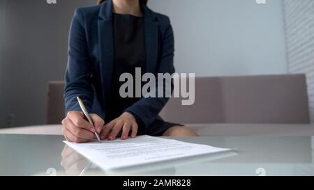 Woman signing documents to receive money, taking loan in bank, startup business Stock Photo