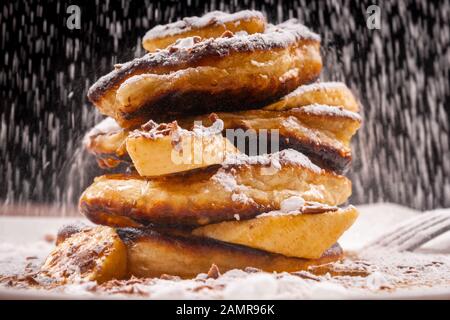 Pancakes with chocolate and banana and powdered sugar falling on top Stock Photo