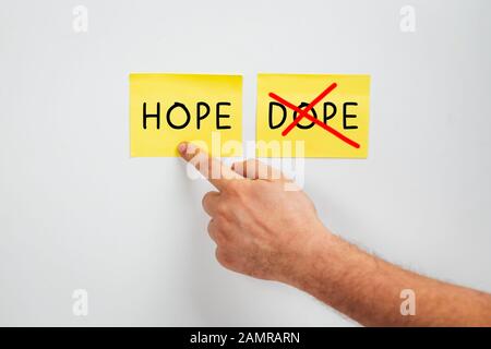 Hope or Dope, Cropped man hand choose Hope - A drug abuse or drug rehabilitation concept - Say no to Dope and yes to Hope Stock Photo