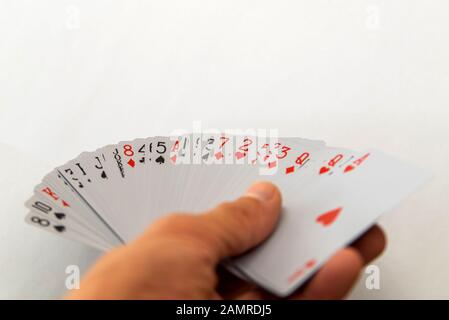 Playing cards in hand isolated on white background. Stock Photo