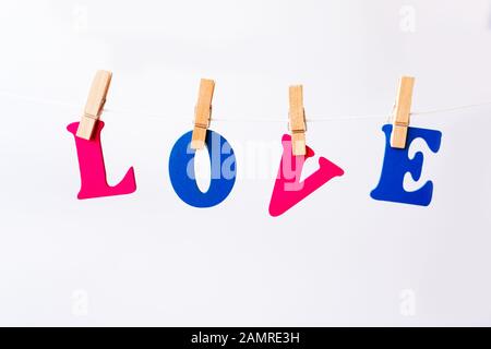 Clothes pegs and I LOVE YOU words on papers on rope on white background Valentines day concept