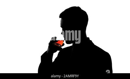 Silhouette of business man drinking whiskey, enjoying taste of aged beverage Stock Photo