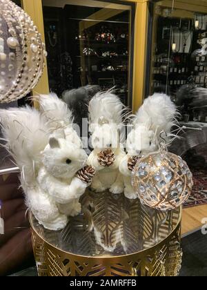 Three squirrels dolls iwith pine cones in hands showcase window of bakery store during winter holidays in France Stock Photo