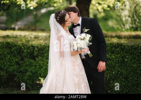 Happy groom and bride walking in the park. Charming woman with handsome man spend time together Stock Photo