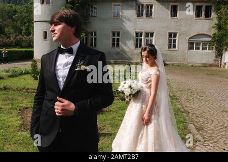 Newlyweds stand in front of castle. Groom and bride Stock Photo