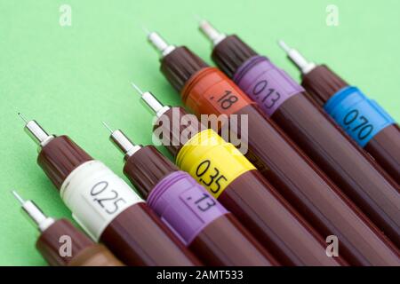 Technical drawing pens on green background. Stock Photo