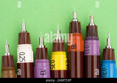 Technical drawing pens on green background. Stock Photo