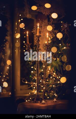 Candlestick on a table in front of a Christmas tree Stock Photo