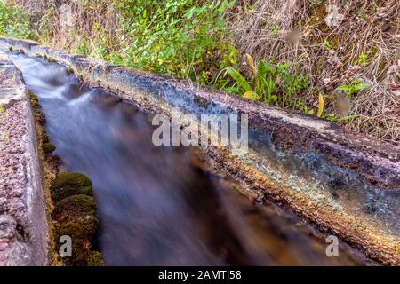 stone water channel full of running water in Tierra del Trigo village Stock Photo