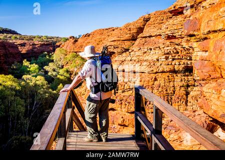 A male hiker rests at the start of the ladder section along the Rim Walk at Kings Canyon in the Northern Territory, in outback Australia. Stock Photo