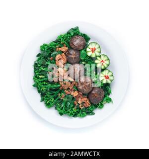 Stir Fried Chinese kale in Oyster sauce with Shitake Mushrooms topped crispy Garlic decorate with carved cucumber vegetables style top view Stock Photo