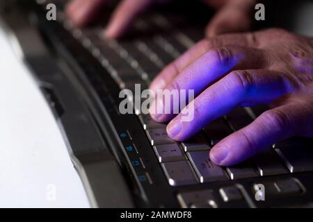 A man works at a computer. Hands of a man on the keyboard close-up. Programmer or hacker Stock Photo
