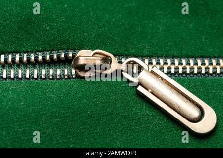 Gold zipper closed binding. Green textile under high magnification. Texture or background Stock Photo