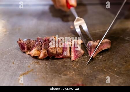 Cooking of beef teppanyaki recipe japanese grilled beef on cooking pan using scraper and knife Stock Photo