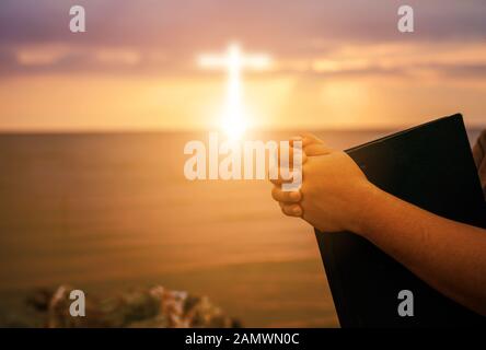 Christian praise on hill thanksgiving day background. Christian man or woman hands holding and reading a bible holy. Hands folded in prayer. worship g Stock Photo