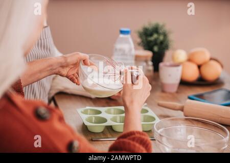 Close up of womans hands holding a whisk for whipping Stock Photo