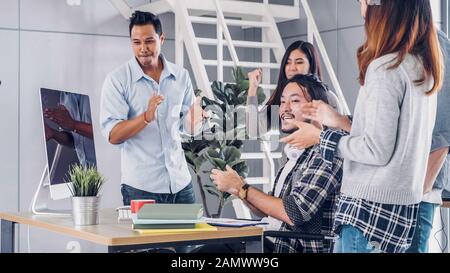 Creative director team applause for good solution of project with designer at table with desktop computer.discussion idea in creative office Stock Photo
