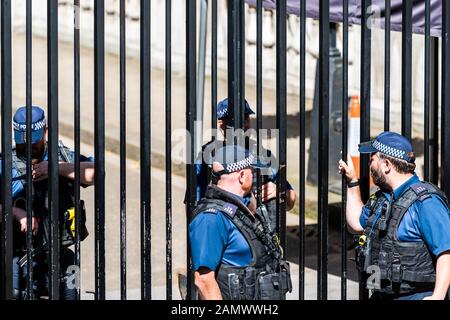 London, UK - June 22, 2018: Police men security guards officers with automatic weapons guns standing talking by Westminster Stock Photo