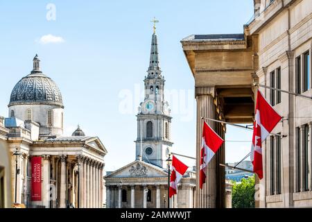 London, UK - June 22, 2018: High Commission of Canada closeup of row of colorful red Canadian flags on Cockspur Street in Westminster and church Stock Photo