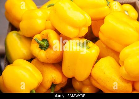 Fresh yellow pepper lying on the market counter. Yellow pepper texture, bright healthy vegetables and vegetatarian texture of yellow peppers Stock Photo