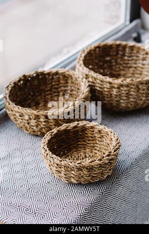 Little braided baskets of natural vines on the sub-house near the window. Eco storage concept. Stock Photo