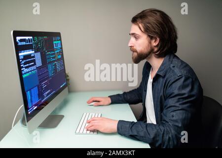 Software developer on the computer screen and is analyzing the code. Stock Photo