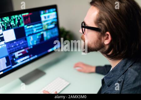 Software developer on the computer screen and is analyzing the code. Stock Photo