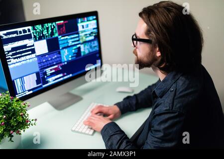 Software developer on the computer screen and is analyzing the code. Stock Photo