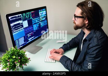 programmer profession - man writing programming code on laptop computer (code on screen is my own property) Stock Photo