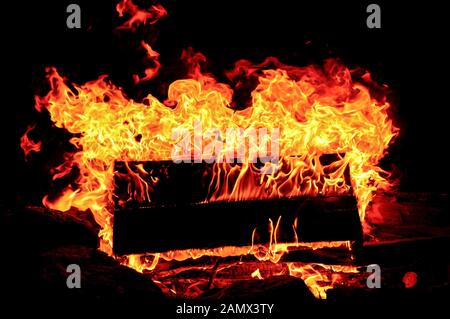 A wooden pallet burns on an outdoor fire in the late evening Stock Photo