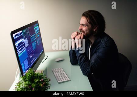 Glad man programer working on computer with win gesture Stock Photo