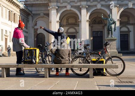 Milan, Italy - January 11, 2020: Some Glovo couriers in a city centre street. Food delivery service. Online ordering. Stock Photo