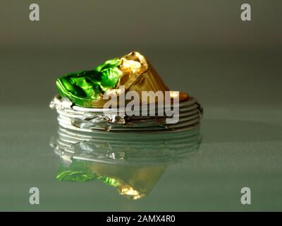 flattened spent aluminum coffee capsules on shiny glass surface. recycling concept. modern lifestyle. environment protection. ecological footprint Stock Photo