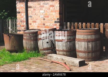 Vintage wooden barrels, left outside in an old yard. Stock Photo