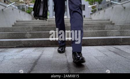 Office worker leaving business center walking down stairs unsuccessful interview Stock Photo