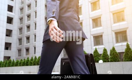Self-confident male in business suit walking near office center building success Stock Photo