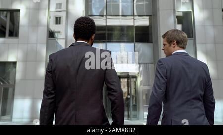 Office workers in suits going to work in modern business center, white collars Stock Photo