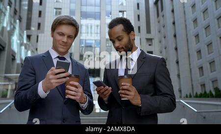 Office workers drinking coffee on break, surfing internet, social network apps Stock Photo