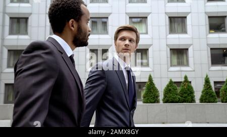 Confident partners discussing joint business project, talking about action plan Stock Photo