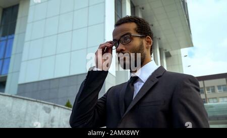 Manager putting eyeglasses on, blurred vision and treatment, eyesight problems Stock Photo