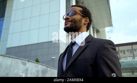 Office worker in eyeglasses smiling happy before weekend, planning time to relax Stock Photo