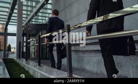 Office workers entering business center in beginning of working day, millennial Stock Photo